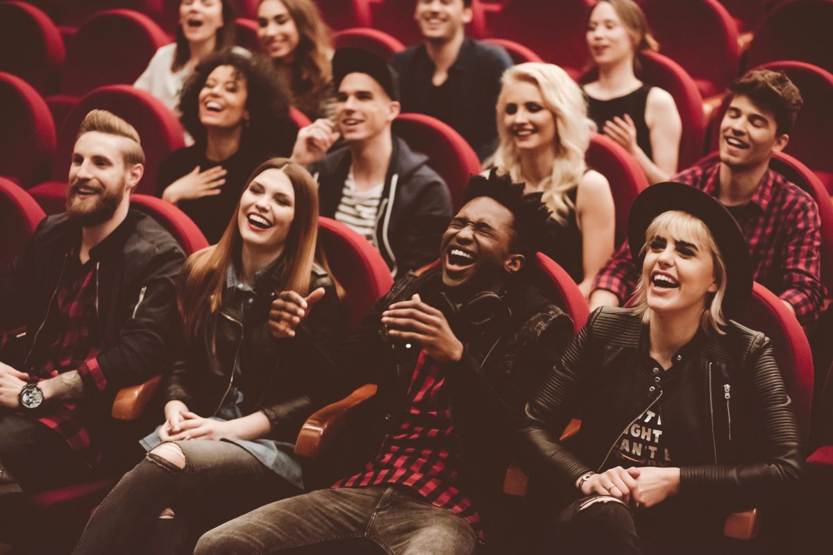 A group of people sitting in the middle of an auditorium.