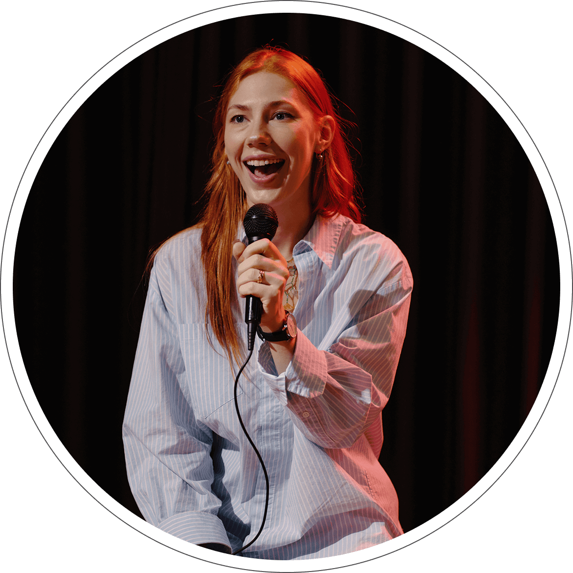 A woman holding a microphone and smiling.