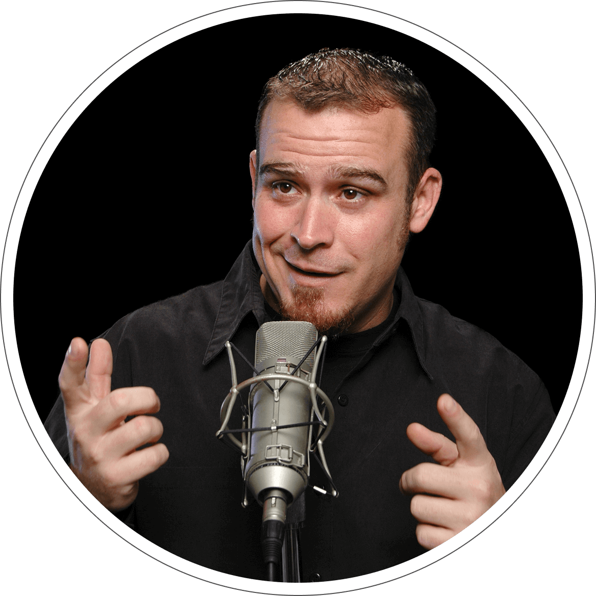 A man is holding up his hands while standing in front of a microphone.