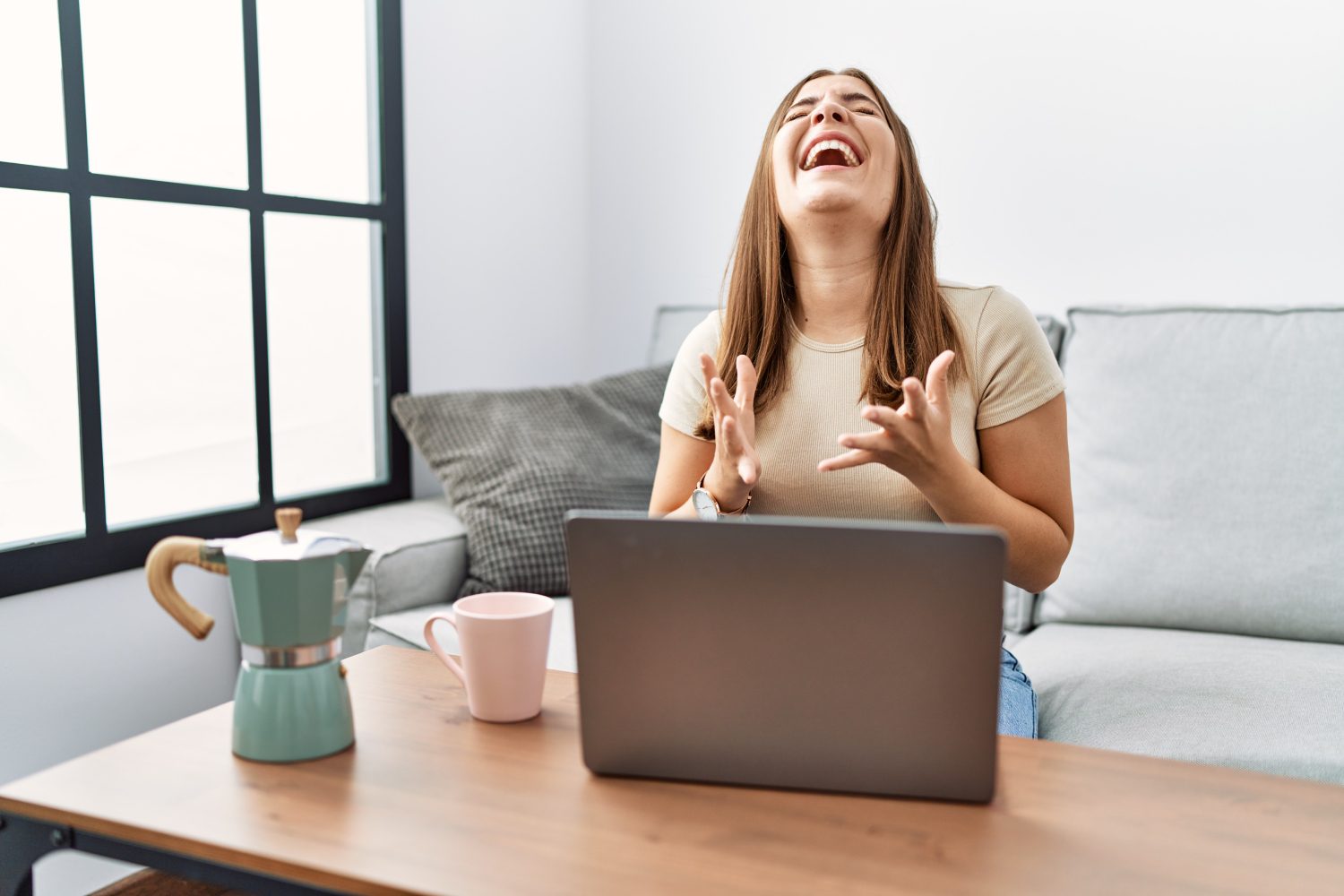A woman sitting at a table with her laptop.