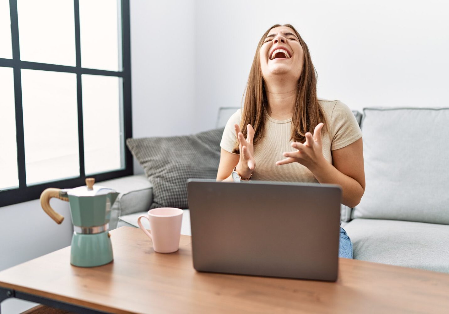 A woman sitting at a table with her laptop.